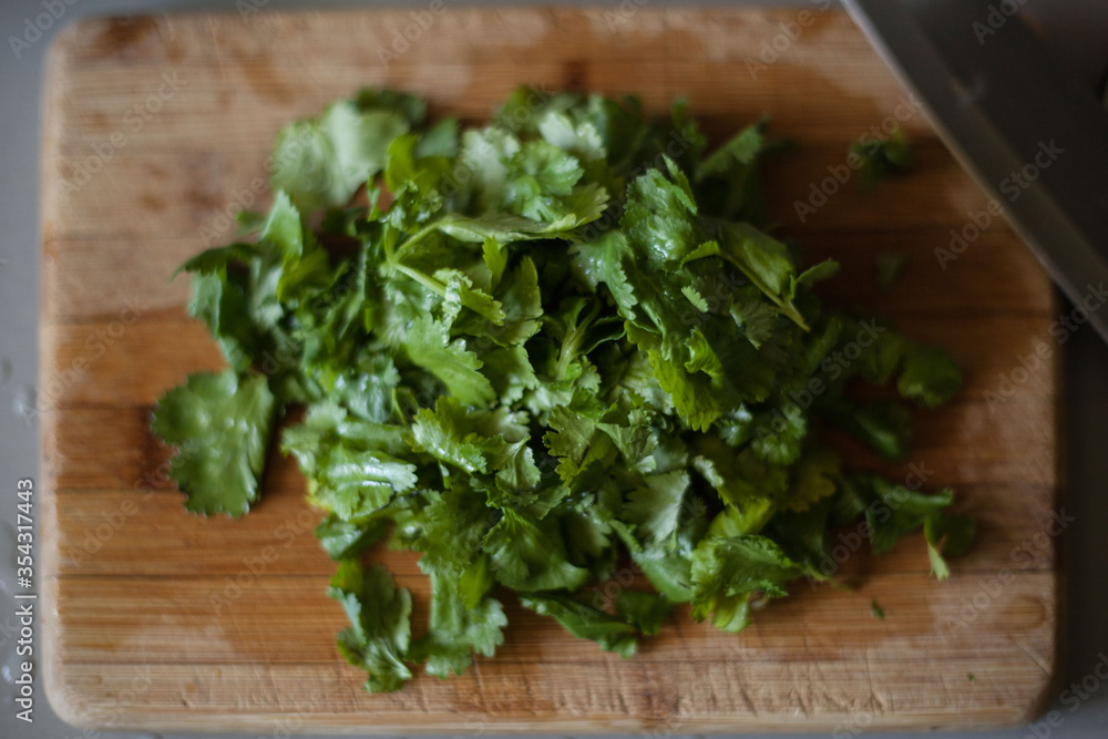 Chopped coriander on wood chopping board Chopped coriander on wood chopping board