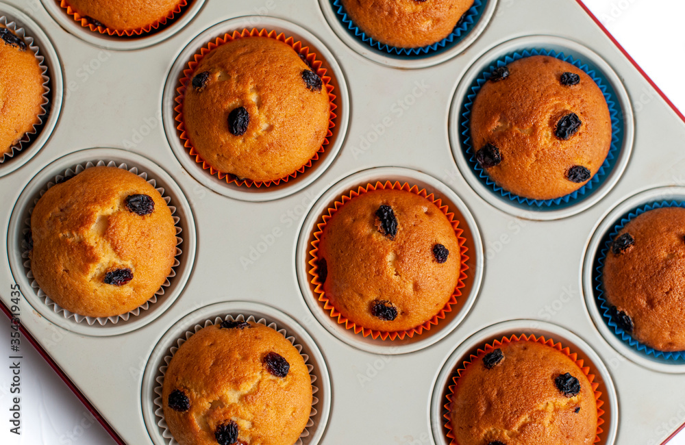 Fresh baked delicious raisin muffins in a oven tray, top view Fresh baked delicious raisin muffins in a oven tray, top view