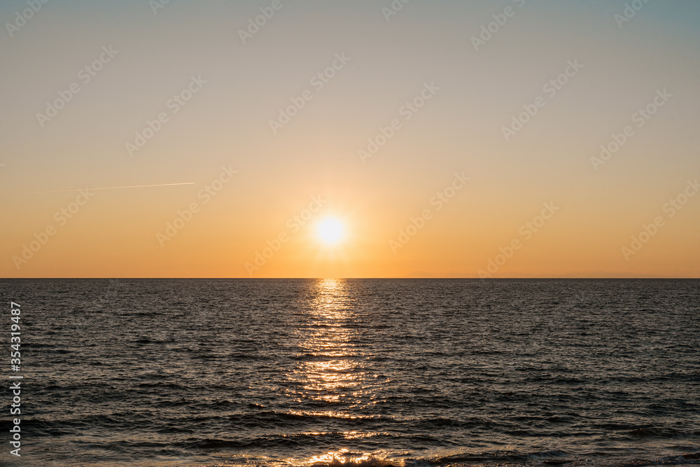 Sea at sunset with beautiful reflections, gradient sky on horizon. Touristic destination.