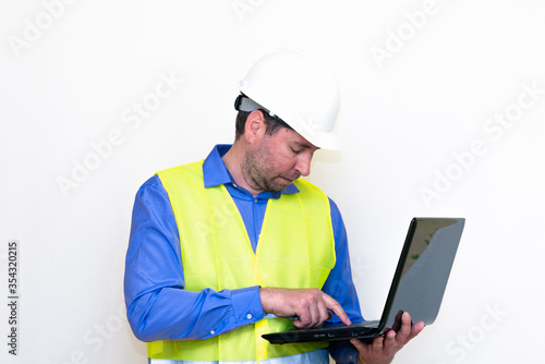Attractive caucasian Technician Holding Laptop Over White Background.Makes all kinds of grimaces-eyes closed, upset, thinking, shows thumb up, and ok gesture...