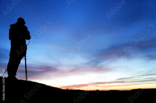 Photographer silhouette in the night sky horizon