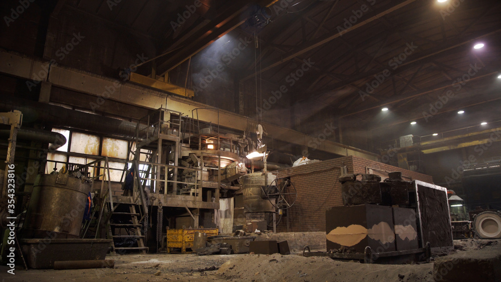 Metal smelting furnace in steel mill. Molten metal pouring, metallurgy, steel casting foundry. Steel manufacturing. Casting shop for gassified models. Metal smelting furnace in steel mill. Molten metal pouring, metallurgy, steel casting foundry. Steel manufacturing. Casting shop for gassified models.