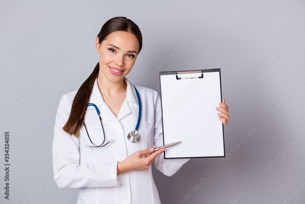 Photo of beautiful professional doc lady showing patient place for signing contract clinic insurance agreement wear stethoscope white lab coat isolated grey color background Photo of beautiful professional doc lady showing patient place for signing contract clinic insurance agreement wear stethoscope white lab coat isolated grey color background
