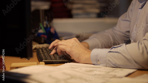 Late at Night in the Office. Design Engineer Works on His Personal Computer. Businessman Working Alone. Graphic Designer Overworked On Computer Late Night. Man typing on keyboard