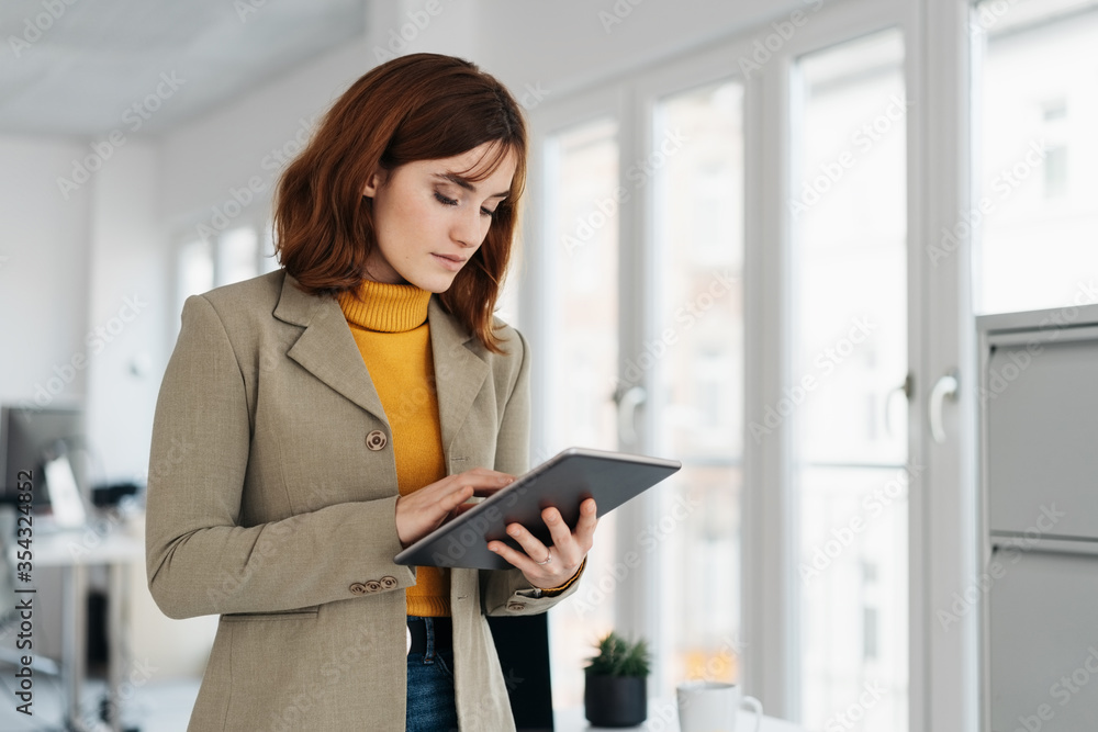 Thoughtful young businesswoman using a tablet Thoughtful young businesswoman using a tablet