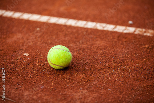 Tennis ball on the clay court. © Pitcher