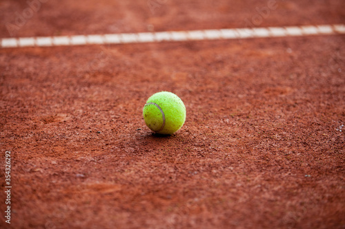 Tennis ball on the clay court. © Pitcher