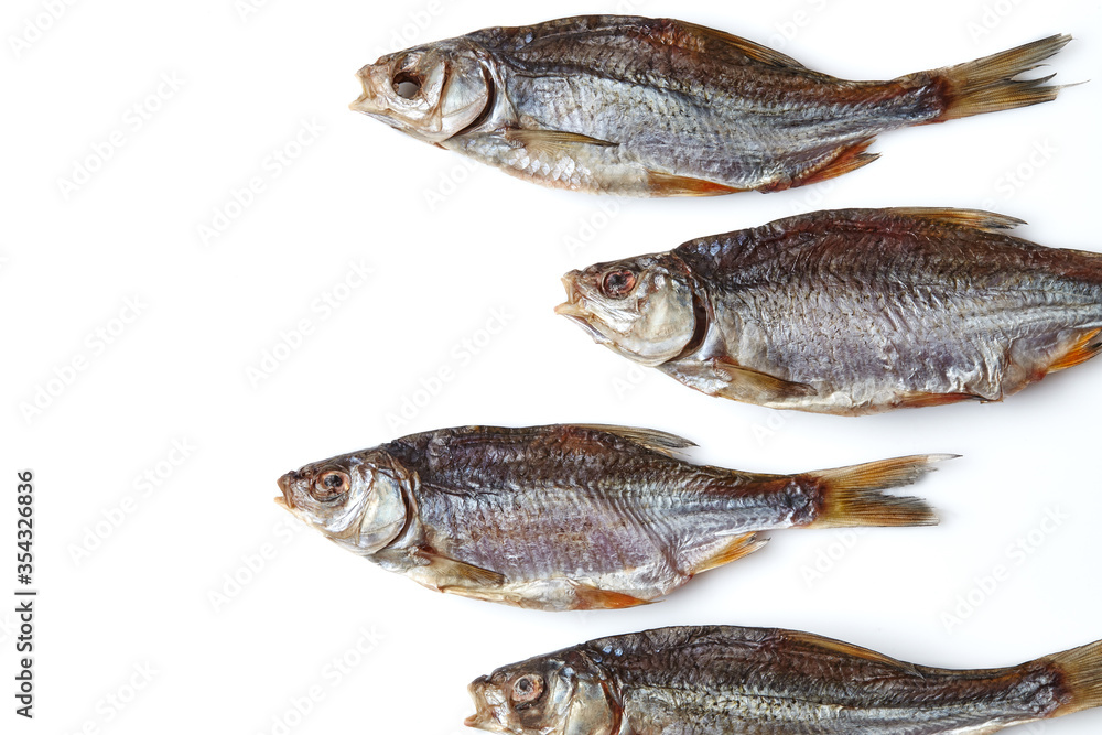 Dried or jerky salted roach, palatable clipfish isolated on white background. Salty beer appetizer. Traditional way of preserving fish. Close up Dried or jerky salted roach, palatable clipfish isolated on white background. Salty beer appetizer. Traditional way of preserving fish. Close up