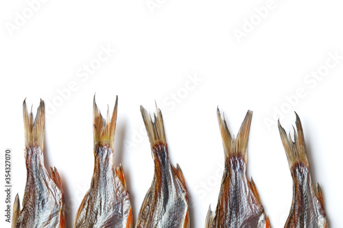 Jerky or dried salted roach tails, clipfish isolated on white background. Beer appetizer. Traditional way of preserving fish. Close up, copy space