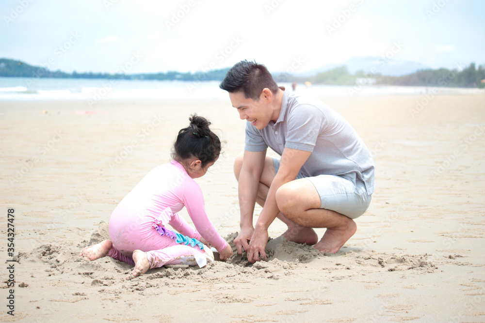 Happy family, father and little daughter having fun and spending time togetheron summer vacation, dad playing with kid on tropical beach