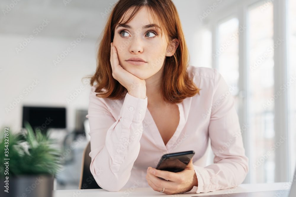 Fototapeta premium Young businesswoman looking thoughtfully aside
