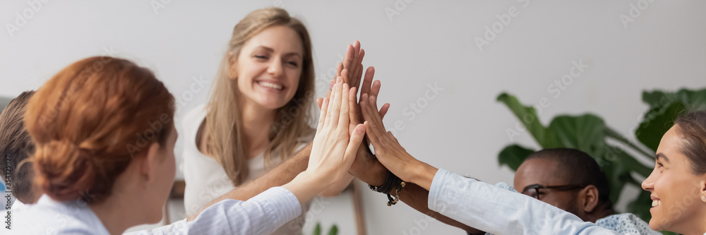 Diverse excited teammates giving high five celebrate common achievements, corporate success gathered at group meeting, team building activity concept. Horizontal photo banner for website header design Diverse excited teammates giving high five celebrate common achievements, corporate success gathered at group meeting, team building activity concept. Horizontal photo banner for website header design