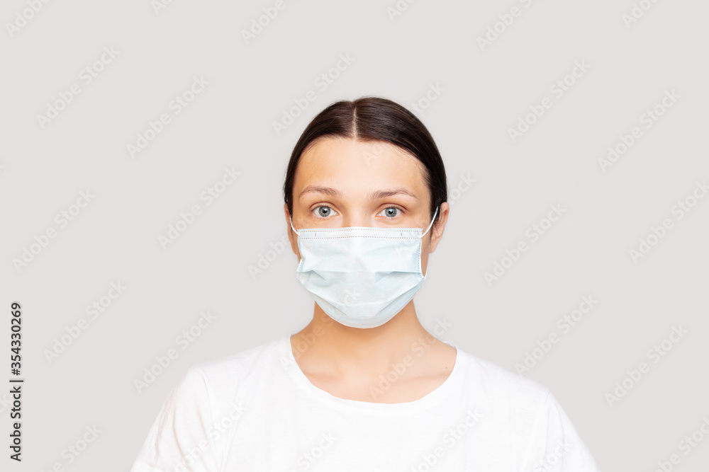 Portrait of a woman adult young in a medical mask on an isolated background Portrait of a woman adult young in a medical mask on an isolated background