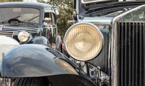 vintage caearly 1900s antique car ,view of the front of a historic car from the early 1900s, vision of the saddle, headlight and mudguard, reflectionsr headlight