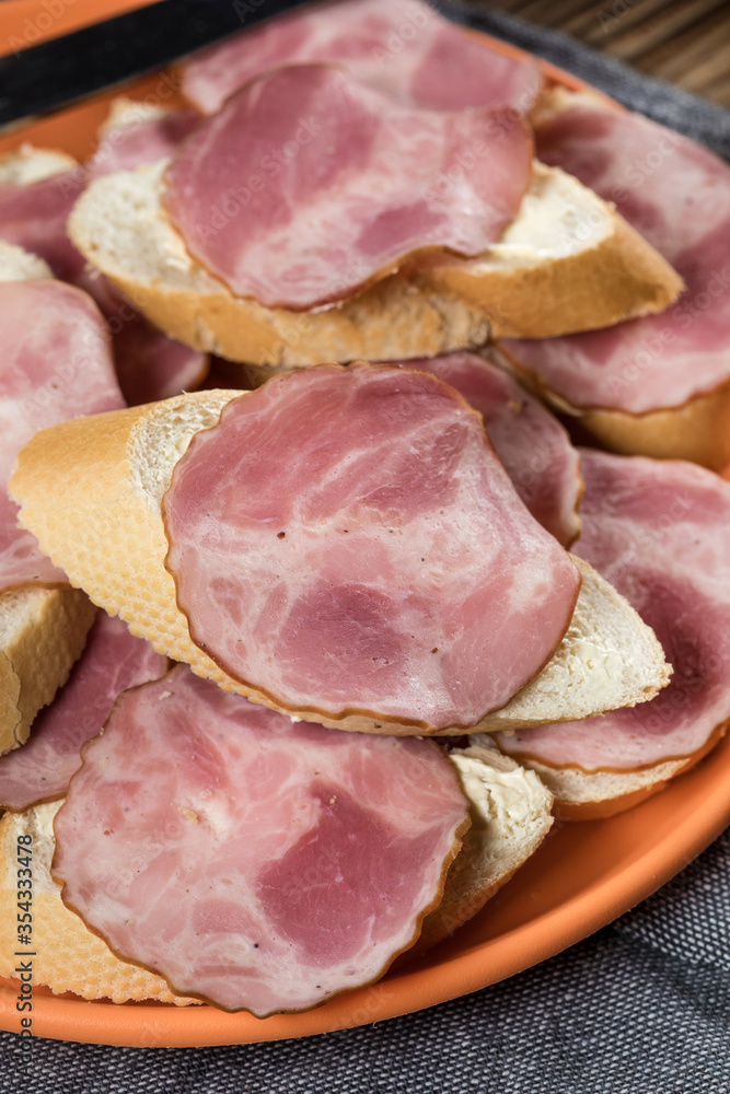 Sandwich made of wheat bread, butter and slices of dry-cured sausage. Sandwich made of wheat bread, butter and slices of dry-cured sausage.