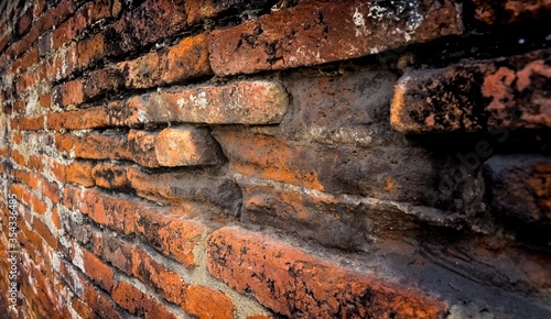 Dark tone of red ancient brick wall in the archaeological site in Thailand with copy space.