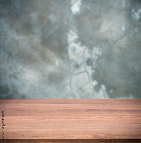 Beautiful wooden table over blur concrete wall background