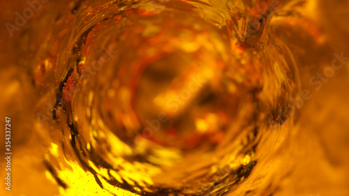 Foto Beer with bubbles moves in a glass in slow motion