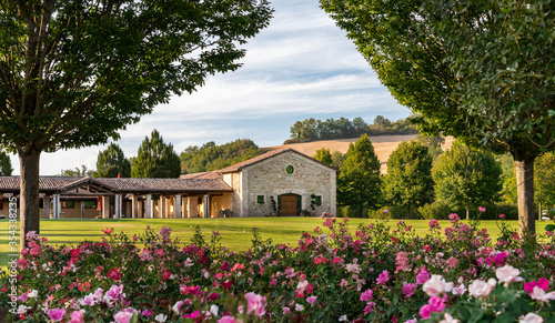 Tuscan village in the countryside, tourist site and relaxation, paved square with stones and grass, typical houses background