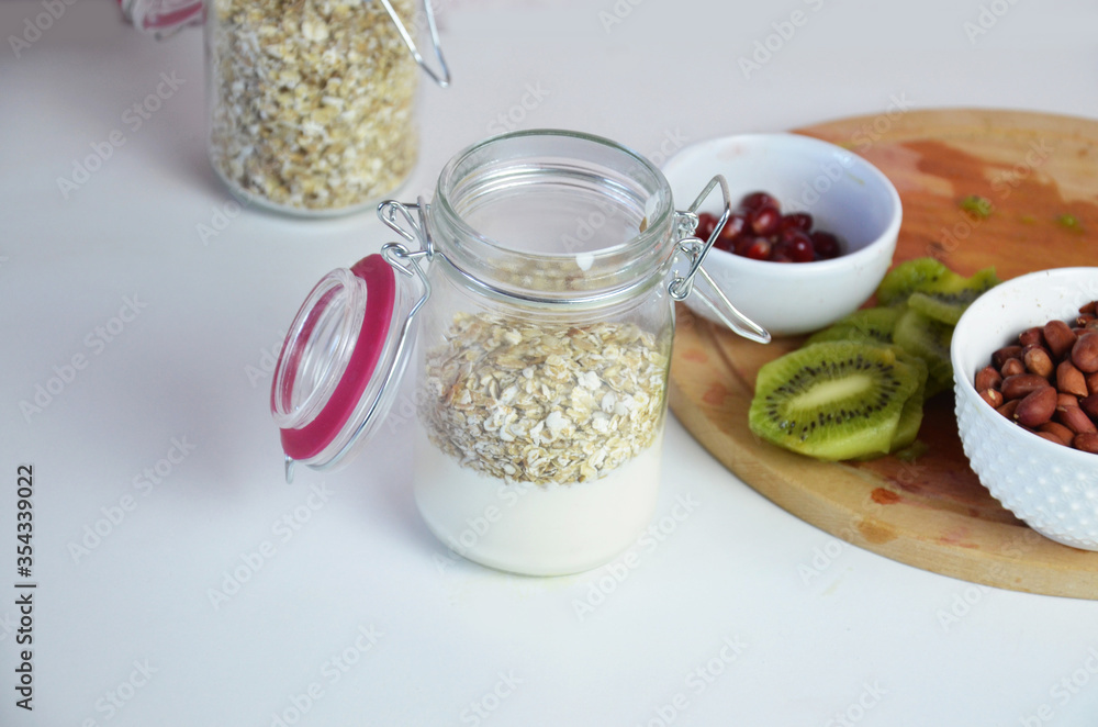 Healthy breakfast overnight oats with fresh berries in a glass jar with dried fruits, apple and nuts, walnuts, almonds. with yogurt, cottage cheese, pudding. diet, keto diet Healthy breakfast overnight oats with fresh berries in a glass jar with dried fruits, apple and nuts, walnuts, almonds. with yogurt, cottage cheese, pudding. diet, keto diet
