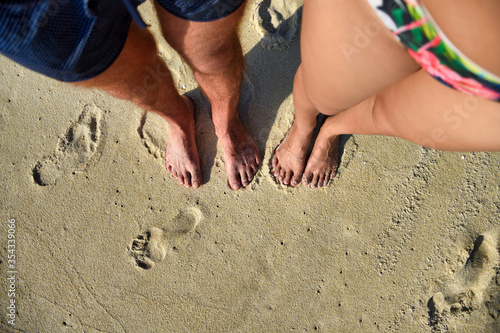 Bare foot standing on the sandy beach and looking to our feet at Langkawi Island