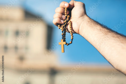 man holds a cross on his hand