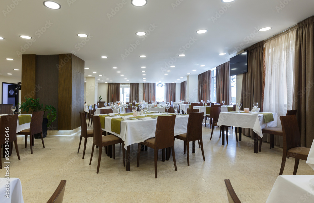 Tables in hotel restaurant with wooden chairs Tables in hotel restaurant with wooden chairs