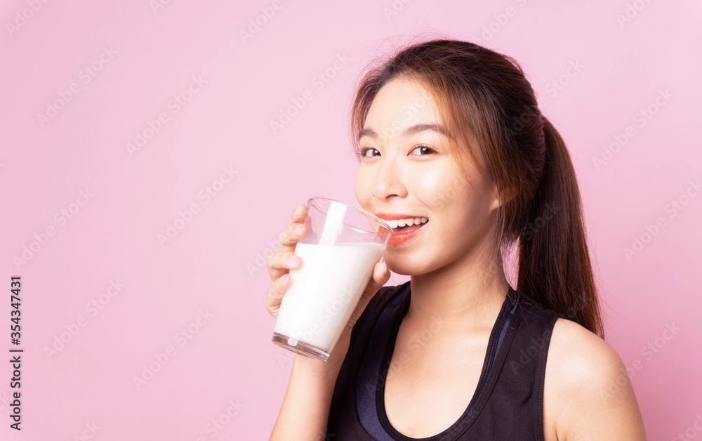 Healthy asian woman diet holding drink glass milk for health, sport portrait girl isolated pink background,healthy drink and clean food concept,copy space Healthy asian woman diet holding drink glass milk for health, sport portrait girl isolated pink background,healthy drink and clean food concept,copy space