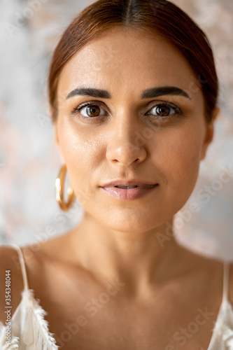 Portrait of beautiuful young woman wearing one earring close up photo