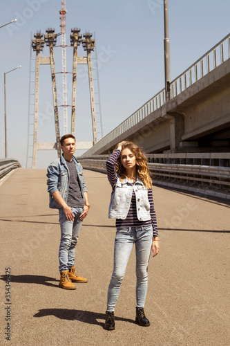 Two young people man and woman wearing jeans outdoors. Fashion concept with beautiful couple.