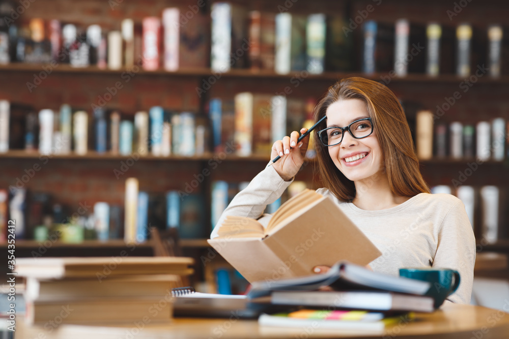Young smiling woman studying with many books at home Young smiling woman studying with many books at home
