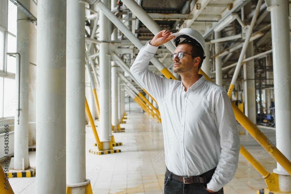 happy male industrial technician inside a factory happy male industrial technician inside a factory