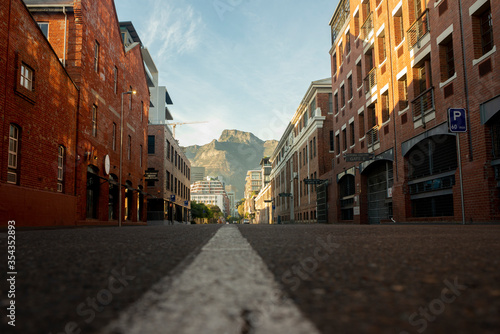 Photography historic brick warehouse buildings with empty road with mountain in background l