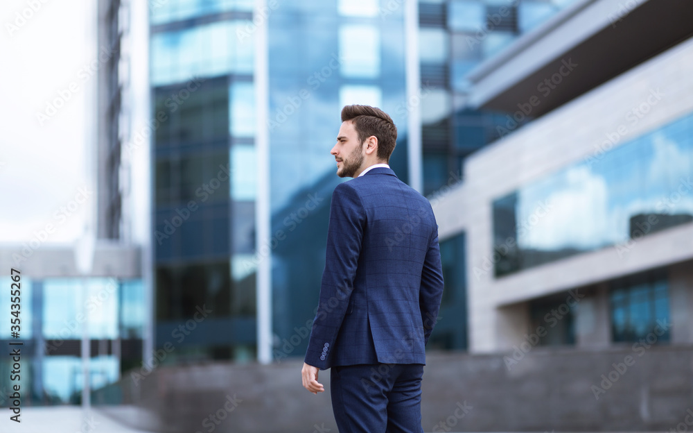 Confident young enterpreneur going to office building at city center Confident young enterpreneur going to office building at city center