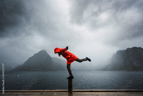 Norway, Lofoten, man balancing on a pole at the coast photo
