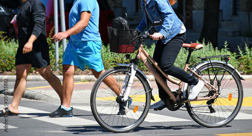 Woman with bicycle on the city street photo