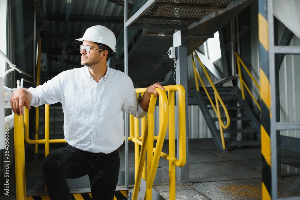 happy male industrial technician inside a factory happy male industrial technician inside a factory