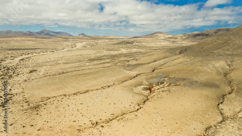 Panorama-Aufnahme einer Wüstenlandschaft mit tiefen Erosionsrinnen, fotografiert mit einer Kameradrohne