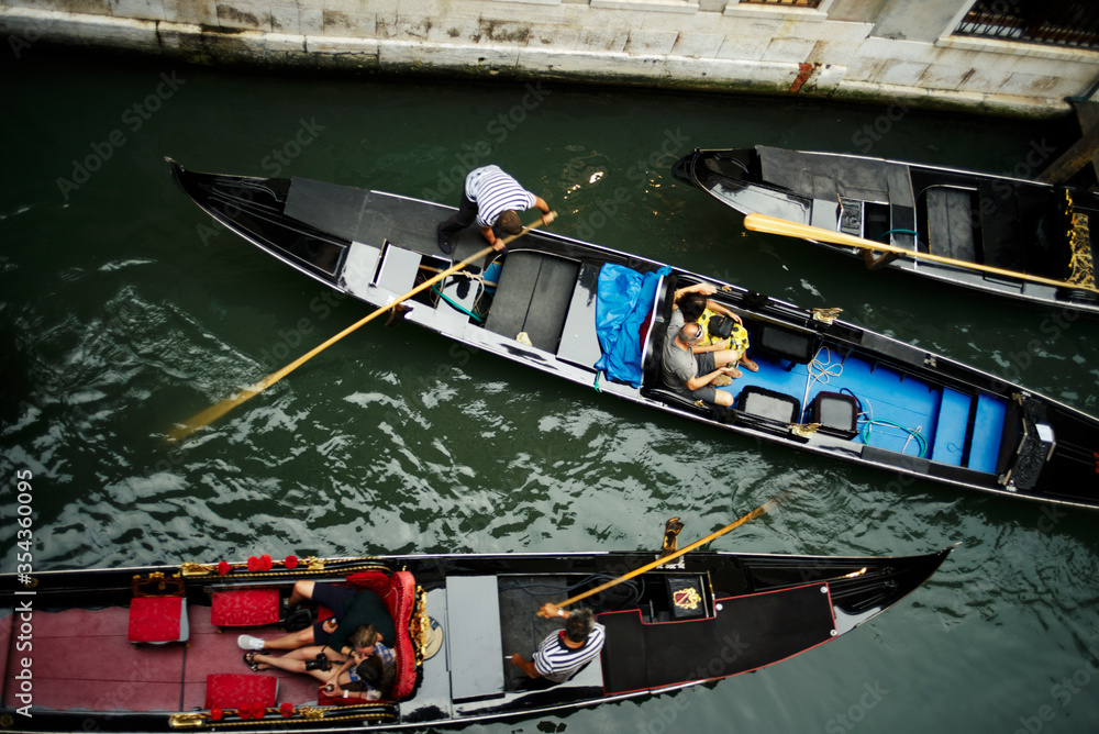 Obraz premium Venice, Italy - August 28, 2018. Tourists in gondolas in a narrow canal in Venice.