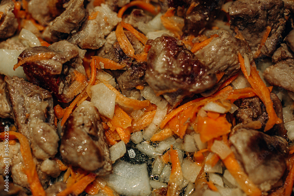 Onions with carrots are fried. Home cooking. Pilaf with meat Onions with carrots are fried. Home cooking. Pilaf with meat