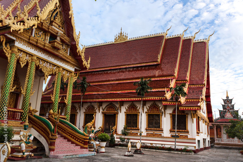 Panoramic view of intensively decorated and painted temple main hall buildings Siamese Lao PDR, Southeast Asia