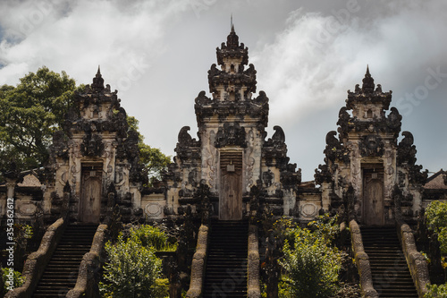 Temple in green with cloudy and grey sky on the background. Indonesia, Bali 2018