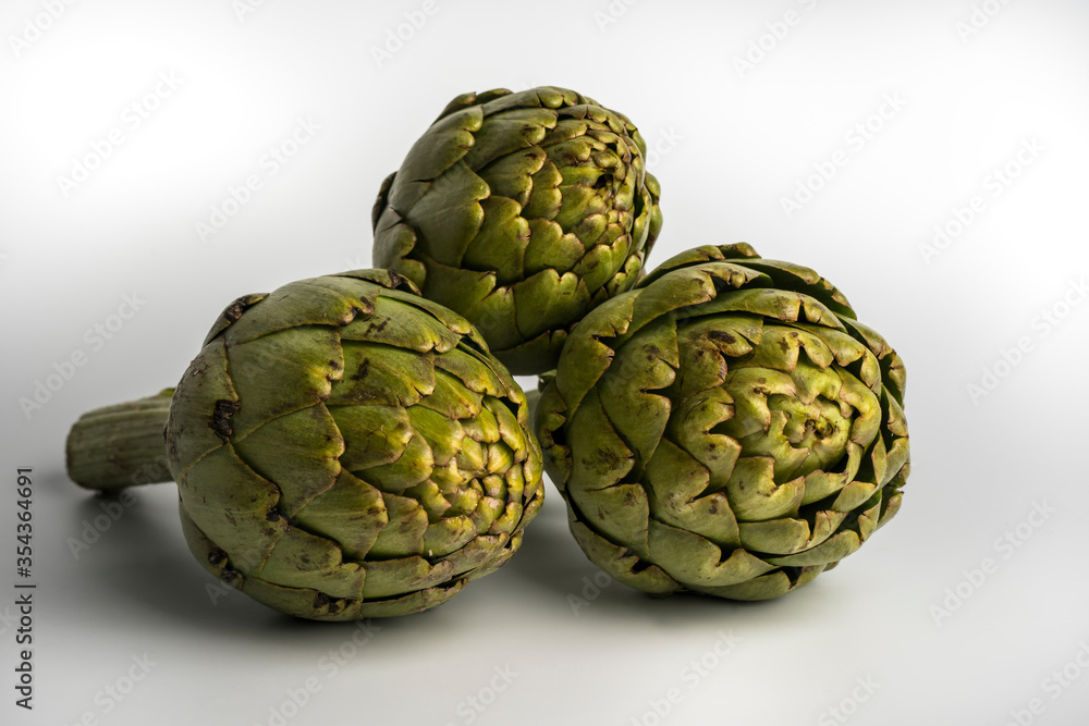 Obraz premium Grupo de tres alcachofas aisladas sobre fondo blanco