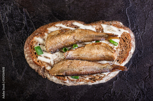 Sandwich with sprots on rye bread lies on a concrete background