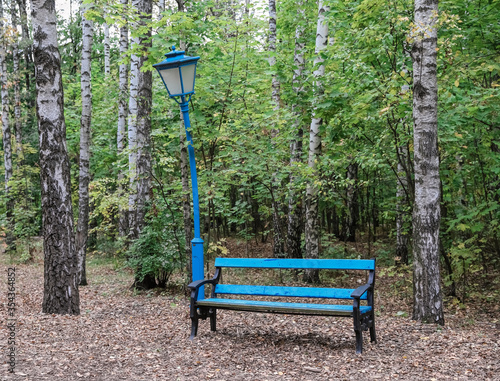 Beautiful blue vintage lantern and bench in autumn park