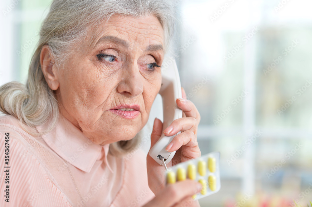 Sick senior woman with medicine calling to hospital Sick senior woman with medicine calling to hospital