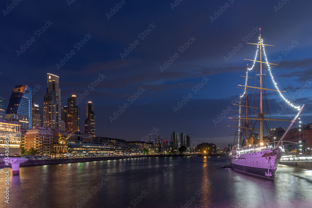 Puerto Madero at night, the buildings and the ship in Buenos Aires with the reflection of the lights in the water
