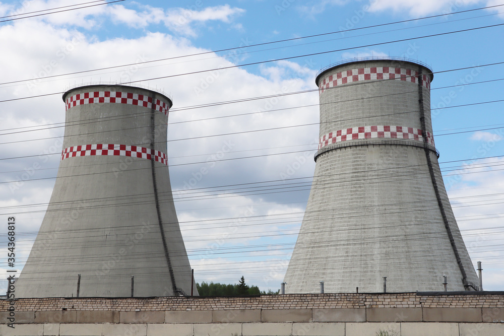 Industrial landscape. Thermal power plant against a blue sky with white clouds.