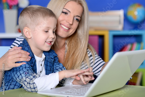 Portrait of mother and son using modern laptop