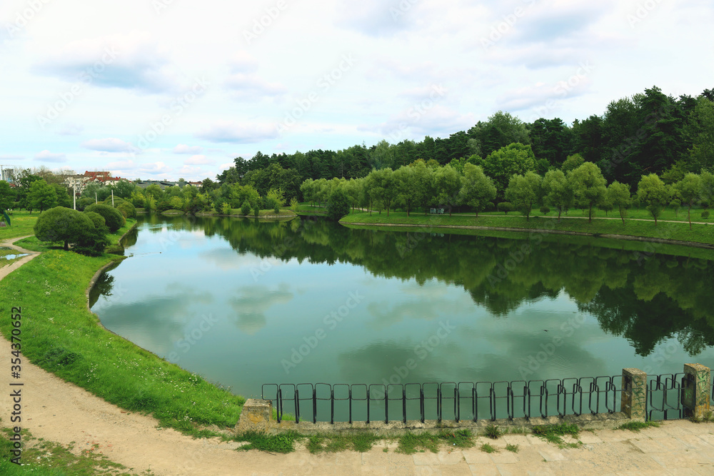 Beautiful landscape of a reservoir against the background of a summer forest and a blue sky with clouds Beautiful landscape of a reservoir against the background of a summer forest and a blue sky with clouds